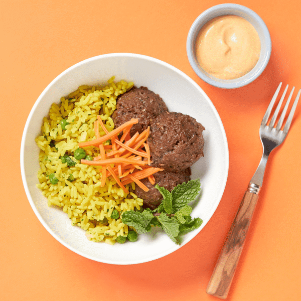 Dairy-free and gluten-free Impossible Bahn Mi Bowl is packed with lemongrass "meatballs" on rice, pickled carrots, and vegan sriracha mayo.