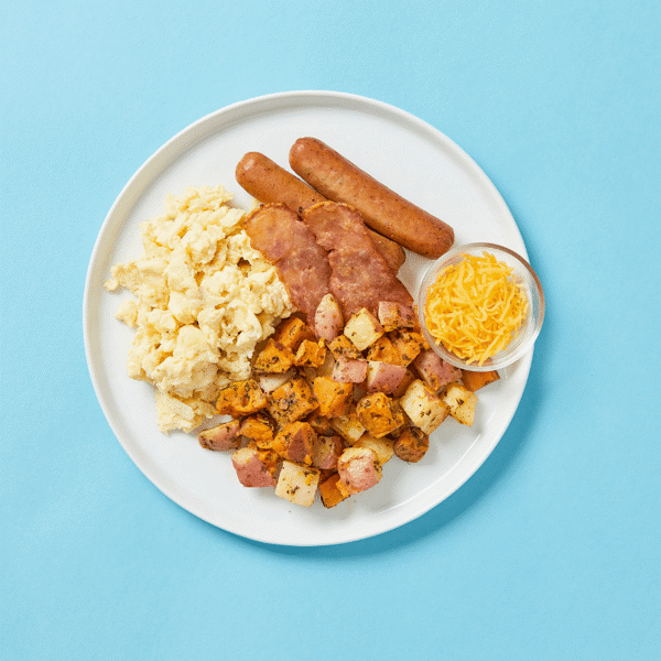 Fitlife Foods' healthy egg scramble, with chicken sausage and bacon, and a side of potato hash browns and shredded cheese.