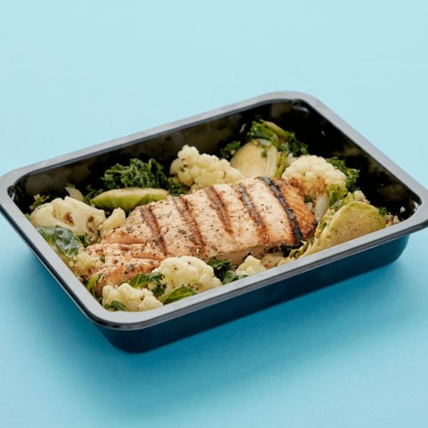 Ready-to-Eat fresh Atlantic salmon, quinoa, and a medley of roasted Brussels sprouts, cauliflower, and kale in a food-safe container