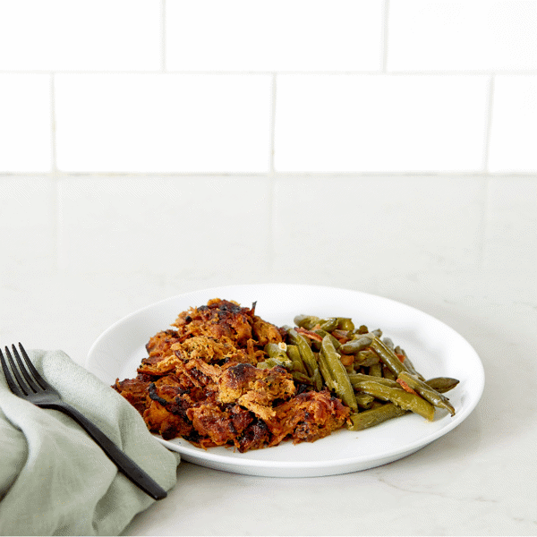 Fitlife Foods' gluten-free, low-carb Carolina Pulled Pork meal prep, featuring pork served with a side of green beans with chicken bacon