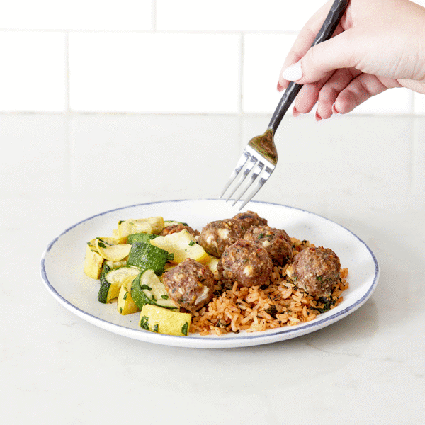 Gluten-free Mediterranean Turkey Meatballs—slow-roasted with feta and herbs and paired with rice and veggies for a nutritious meal.