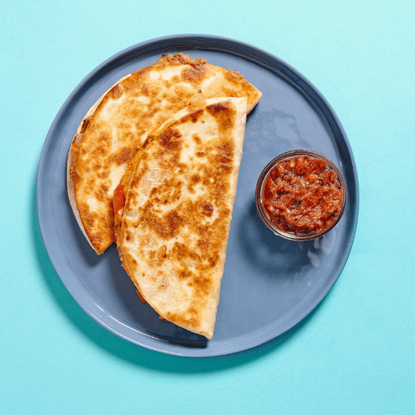 Chicken Quesadilla featuring all-natural grilled chicken, roasted onions, and sautéed peppers served with a side of roasted salsa rioja.