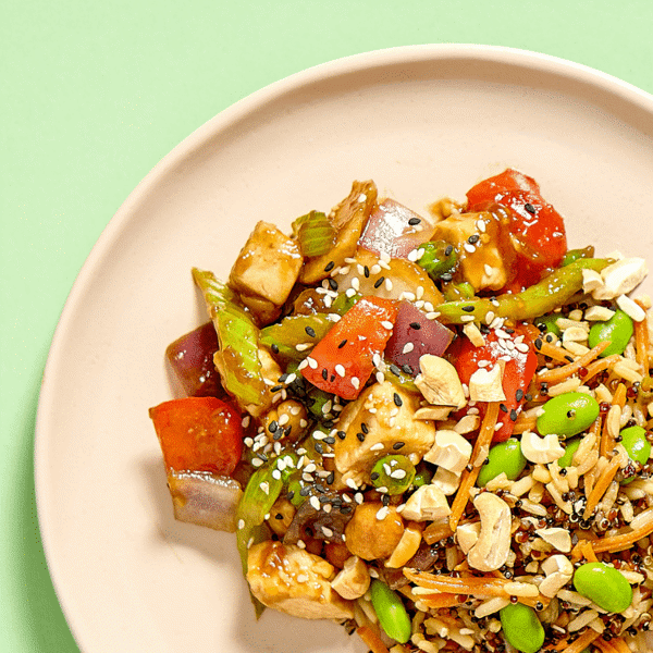 A close-up of a healthy stir-fry feast with roasted chicken, crisp vegetables, and toasted cashews, a delightful gluten-free and dairy-free option