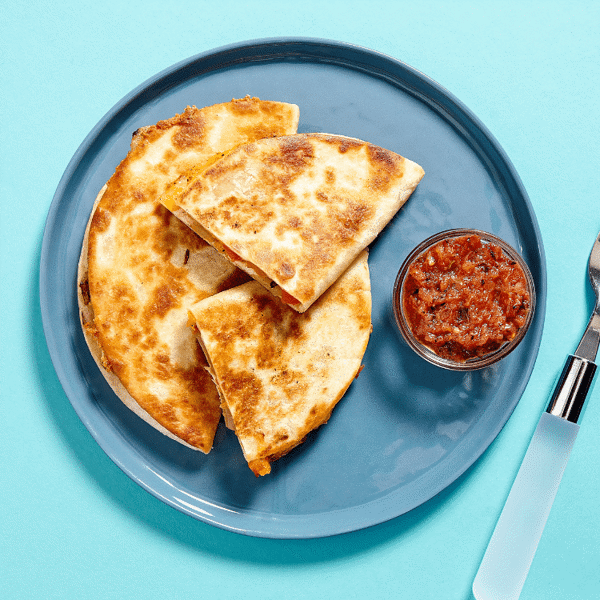 A healthy meal with Fitlife Foods' Chicken Quesadilla is prepared with grilled chicken, sautéed veggies, and pinto beans.