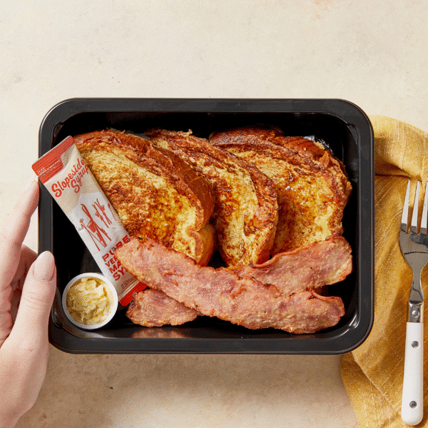 Pumpkin French toast drizzled with maple syrup, crispy chicken bacon, and plant-based butter for a nutritious breakfast on the go.