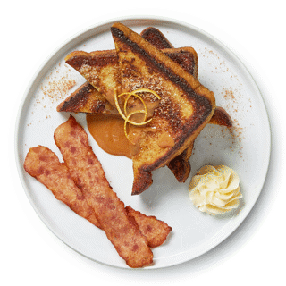 Three pieces of cinnamon and orange-laced French toast griddled to perfection, served alongside crispy chicken bacon and dulce de leche