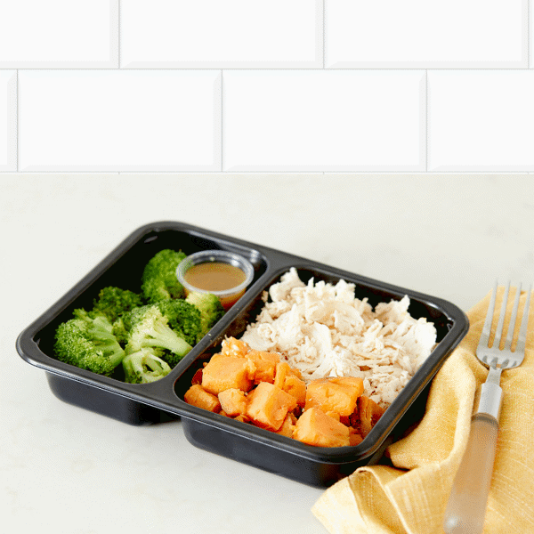A nutritious combination of grilled chicken, roasted sweet potatoes, and steamed broccoli with citrus glaze in a BPA-free container