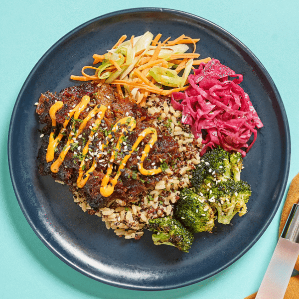 Korean-style roasted pork, brown rice & quinoa, steamed carrots & green onions, broccoli, sweet pickled red cabbage, and a side of sauce.